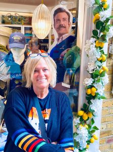 A woman sitting in front of a store window.